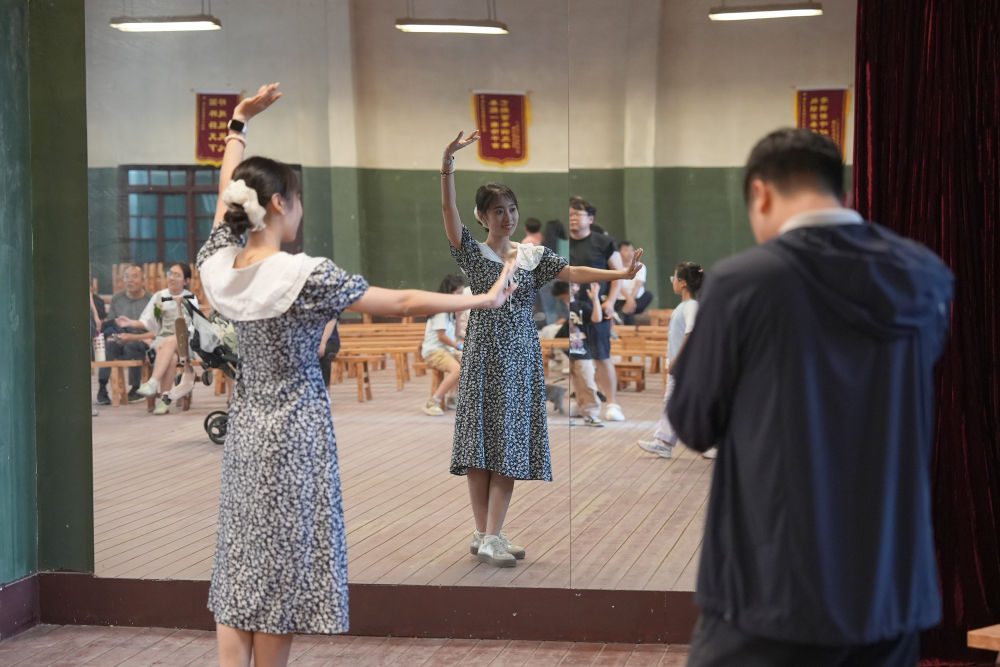 在西影风雷年代影视基地,游客在电视剧《主角》中的省秦剧团排练厅内摆拍秦腔剧目中的动作。新华社记者 邵瑞 摄