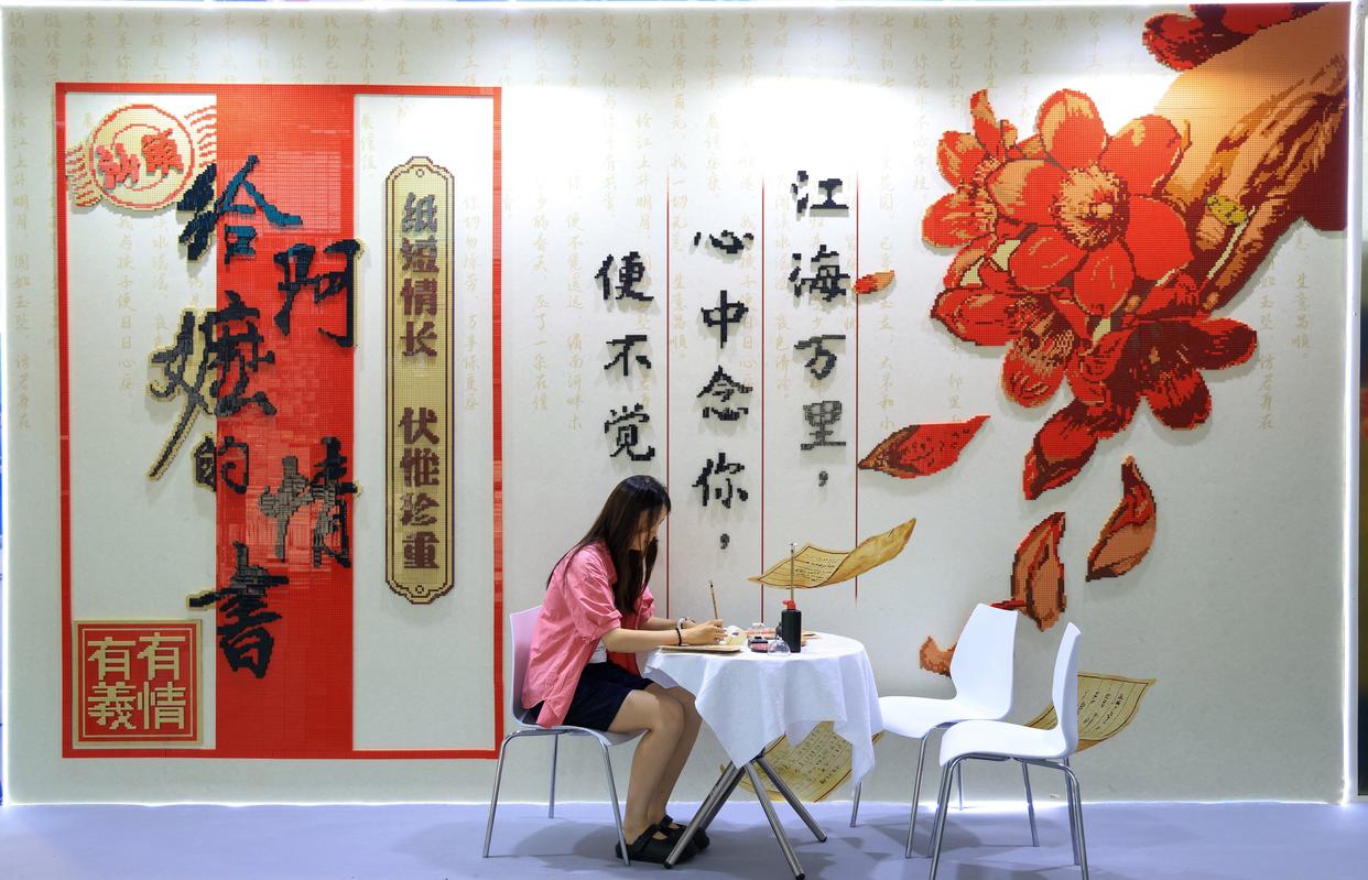 游客在《给阿嬷的情书》电影主题积木打卡墙前体验写批。来源:央视网